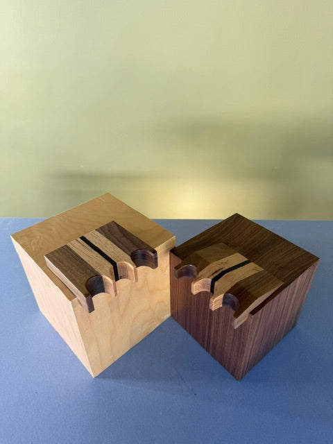 Two Pool Cue Claws with a light and dark color stain with black stripe going through that can hold three pool cues. 

Place Hardwood Pool Cue Claw With Sleek Design Element Bevel and Angled Cue Spot
