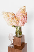 Two boxes made out of walnut holding a wineglass and flowers. 