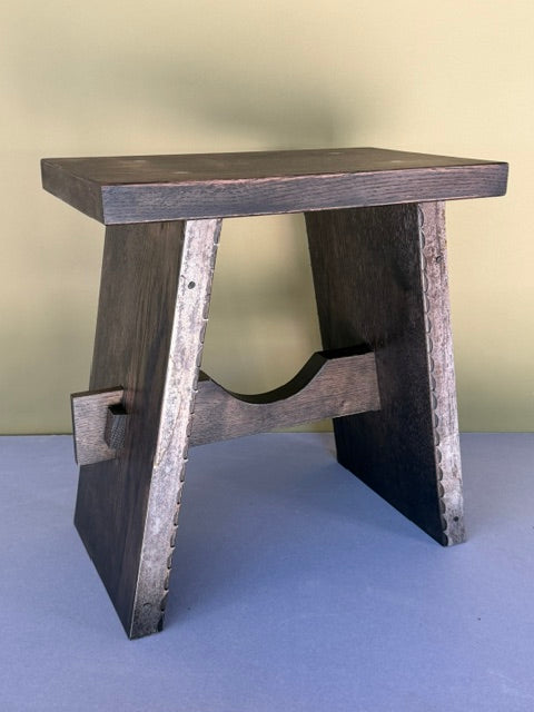 A small hand crafted dark stained oak bench. 
