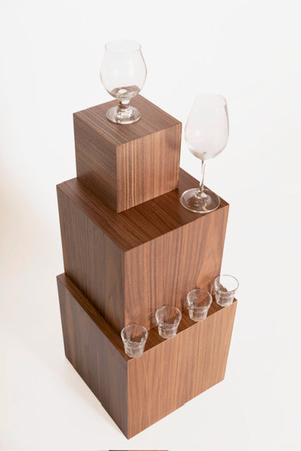 Stacked boxes in varying sizes from small to large, holding wine glasses and shot glasses. 